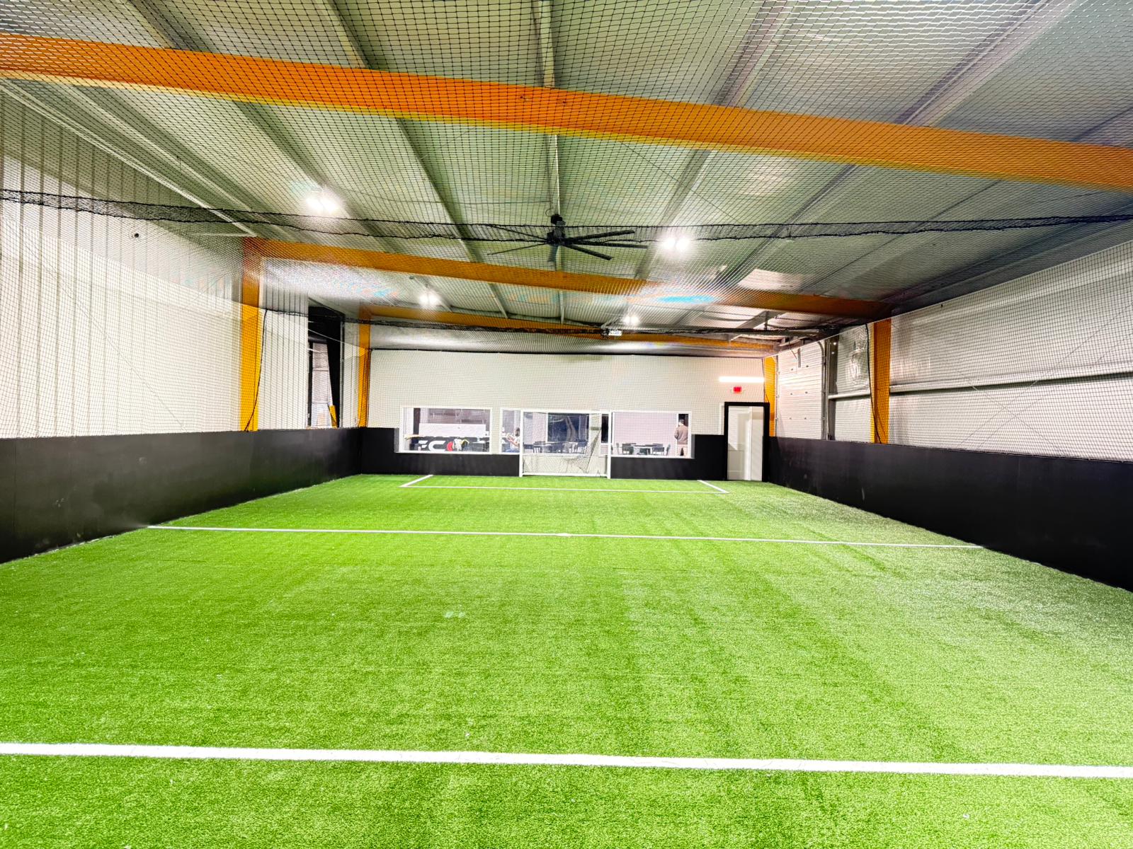 Floodlit indoor-style soccer field at night